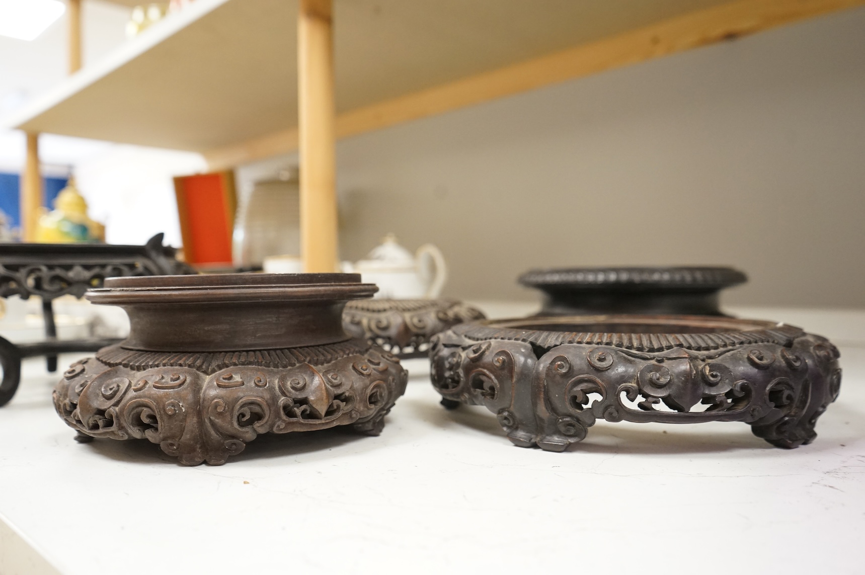 A collection of five Chinese and Japanese carved hardwood stands, late 19th/early 20th century, largest 25cm in diameter